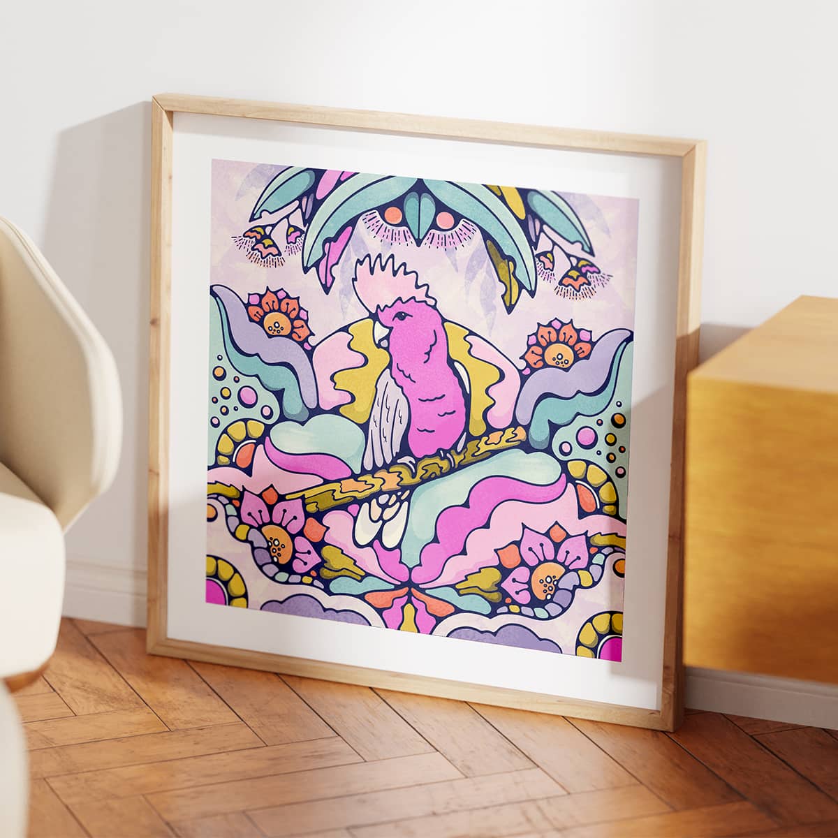 Pretty pink galah bird wall art in a wooden frame sitting on the floor